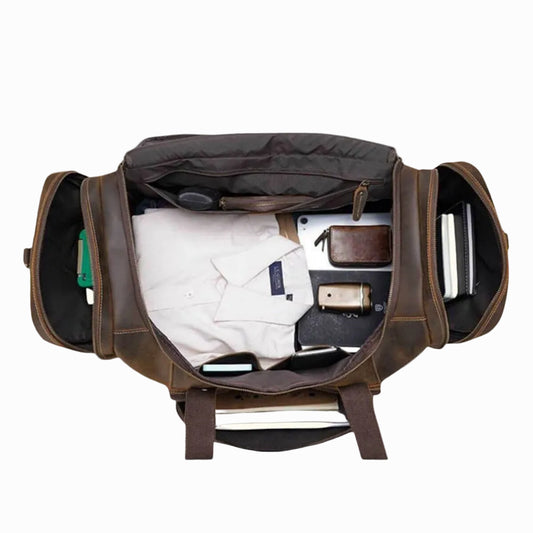 brown vintage leather bag for travel with various items on a white background