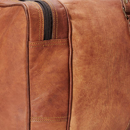 Close-up of a brown leather duffle bag with visible stitching