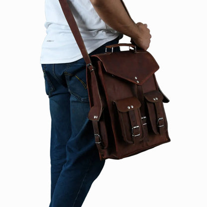 Person holding a vintage distressed unisex sheepskin brown leather satchel bag against a gray background