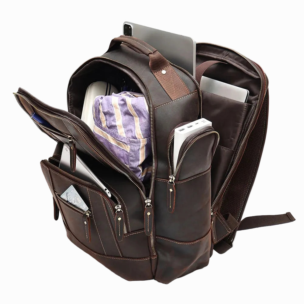 Handmade Brown leather Sheepskin backpack with various items inside on a light gray background