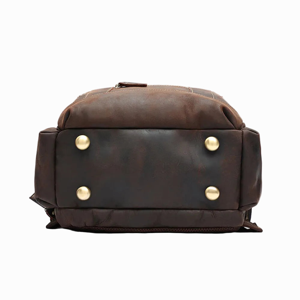 Handmade Brown Sheepskin leather backpack with gold buttons on a light gray background