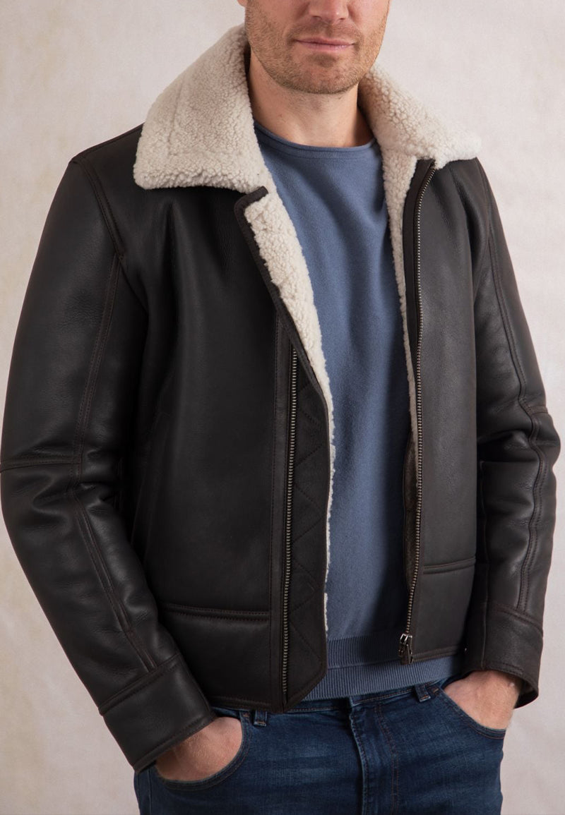 Man wearing a brown shearling jacket mens vintage with a white fur collar against a neutral background