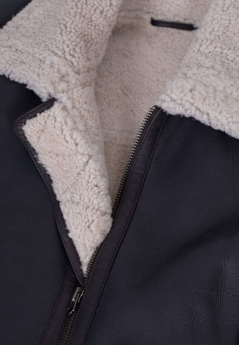 Close-up of a brown shearling aviator jacket with beige sherpa lining