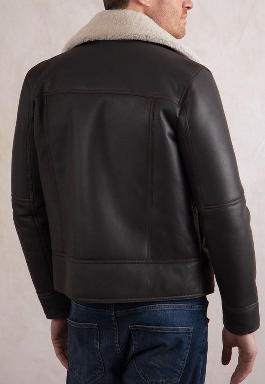A brown shearling leather jacket worn by a man on a plain background
