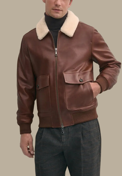 Brown leather bomber jacket with cream fur collar worn by a person against a plain background