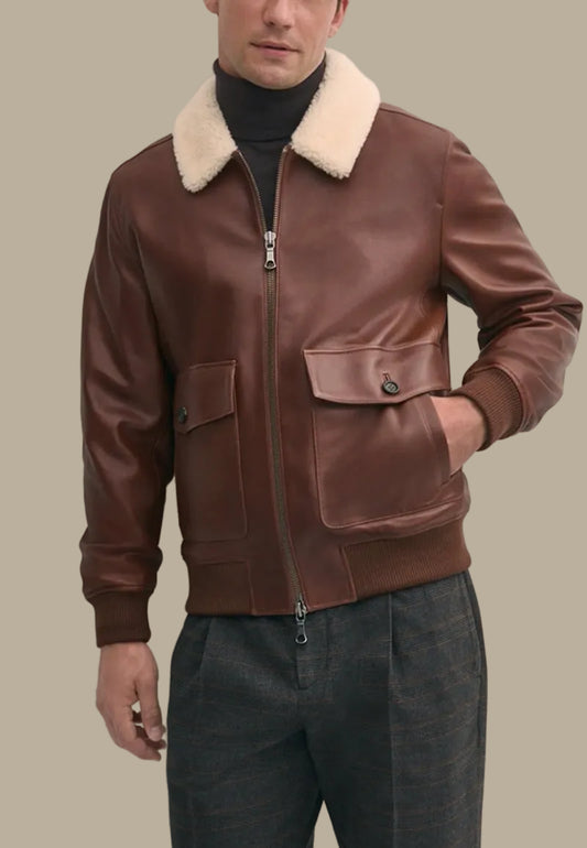 Brown leather bomber jacket with cream fur collar worn by a person against a plain background