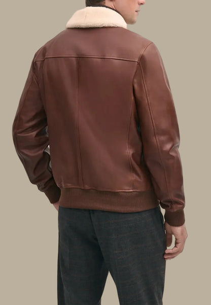 vintage Brown leather bomber jacket with fur collar worn by a person on a beige background