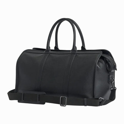 Black leather vintage duffel bag with handles and a strap on a light gray background