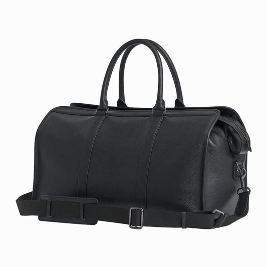 Black leather vintage duffel bag with handles and a strap on a light gray background