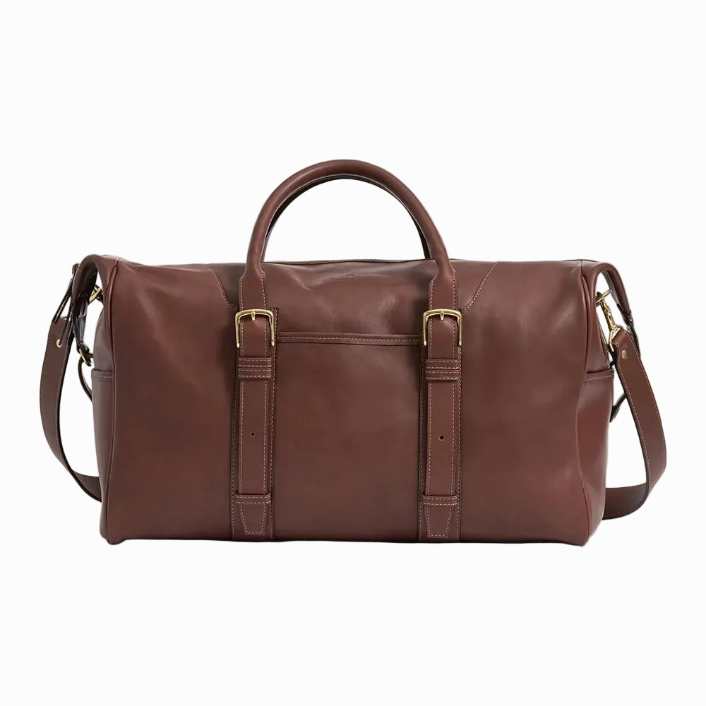 Brown vintage leather duffel bag with gold buckles on a plain background