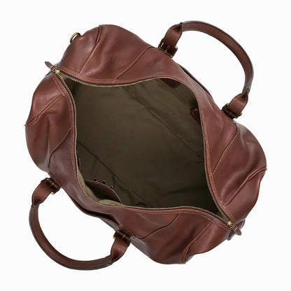 Vintage Brown leather travel and gym duffel bag with gold buckles on a beige background