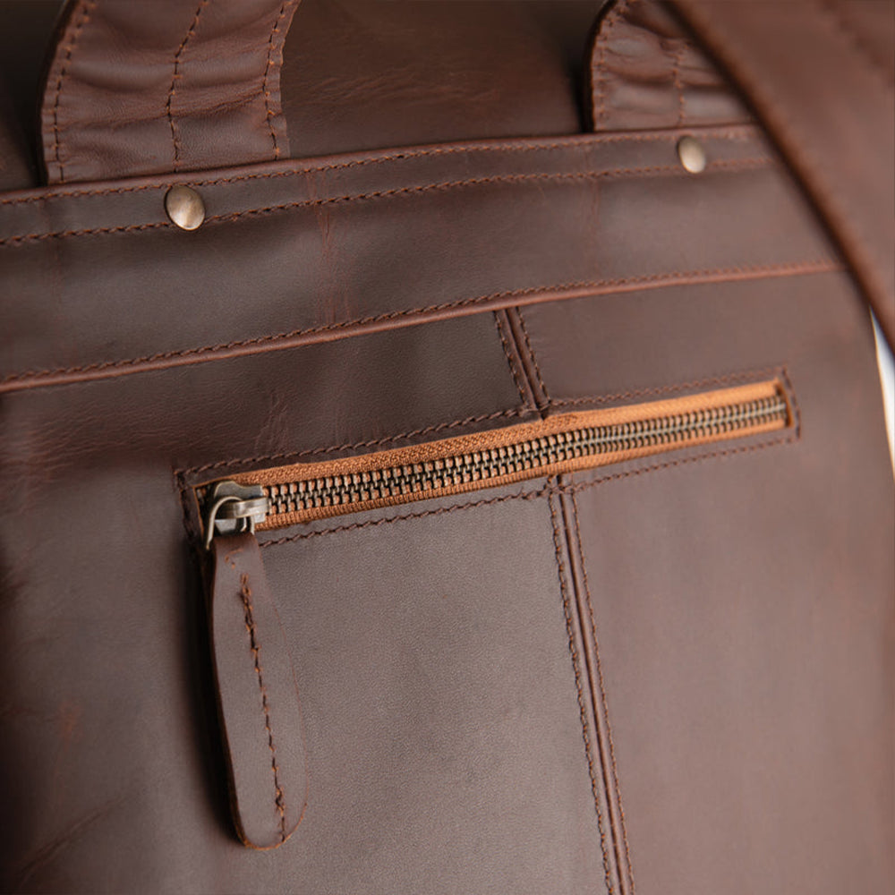 Close-up of a handmade brown sheepskin leather bag with a zipper