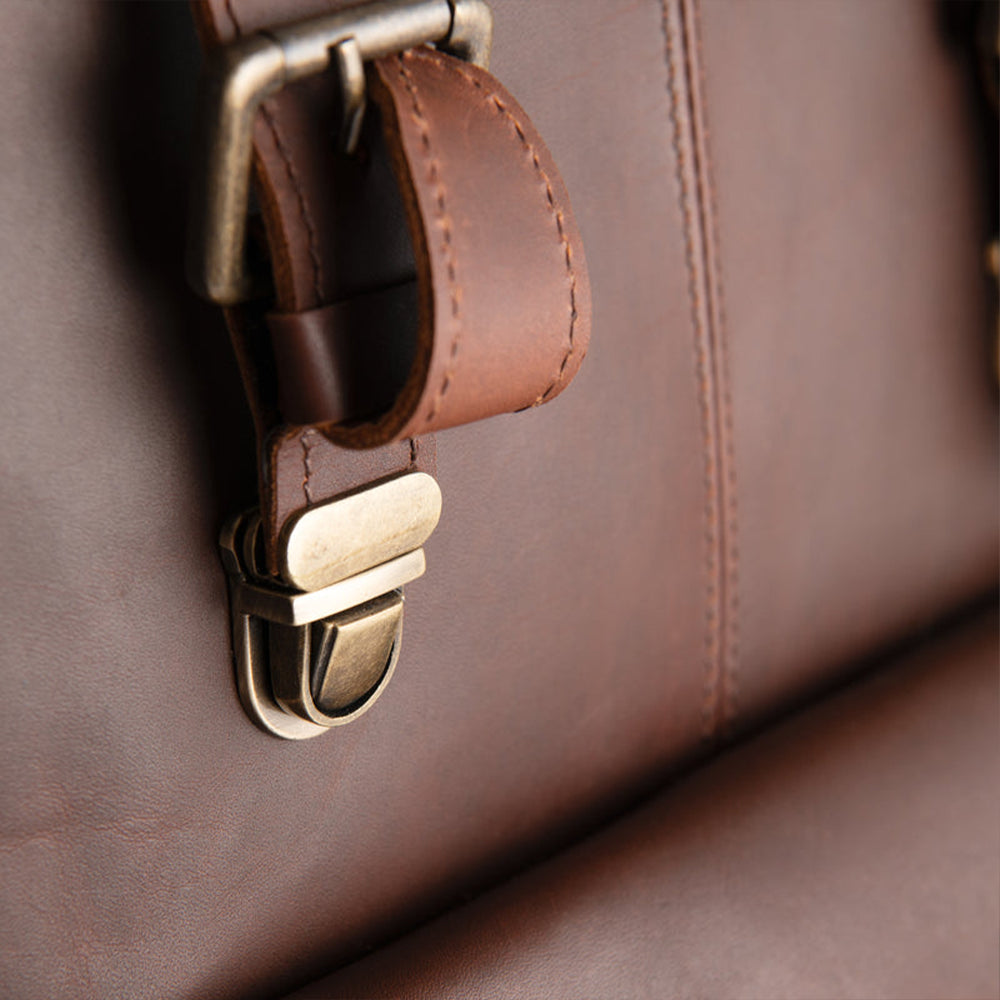 Close-up of a handmade brown sheepskin leather bag with a metal buckle