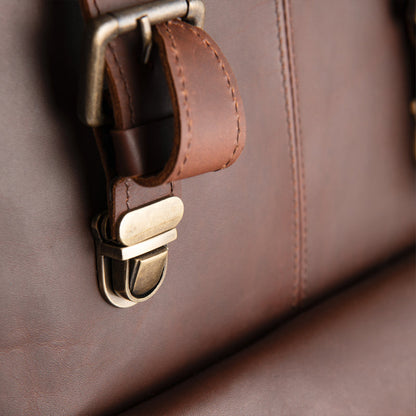 Close-up of a handmade brown sheepskin leather bag with a metal buckle