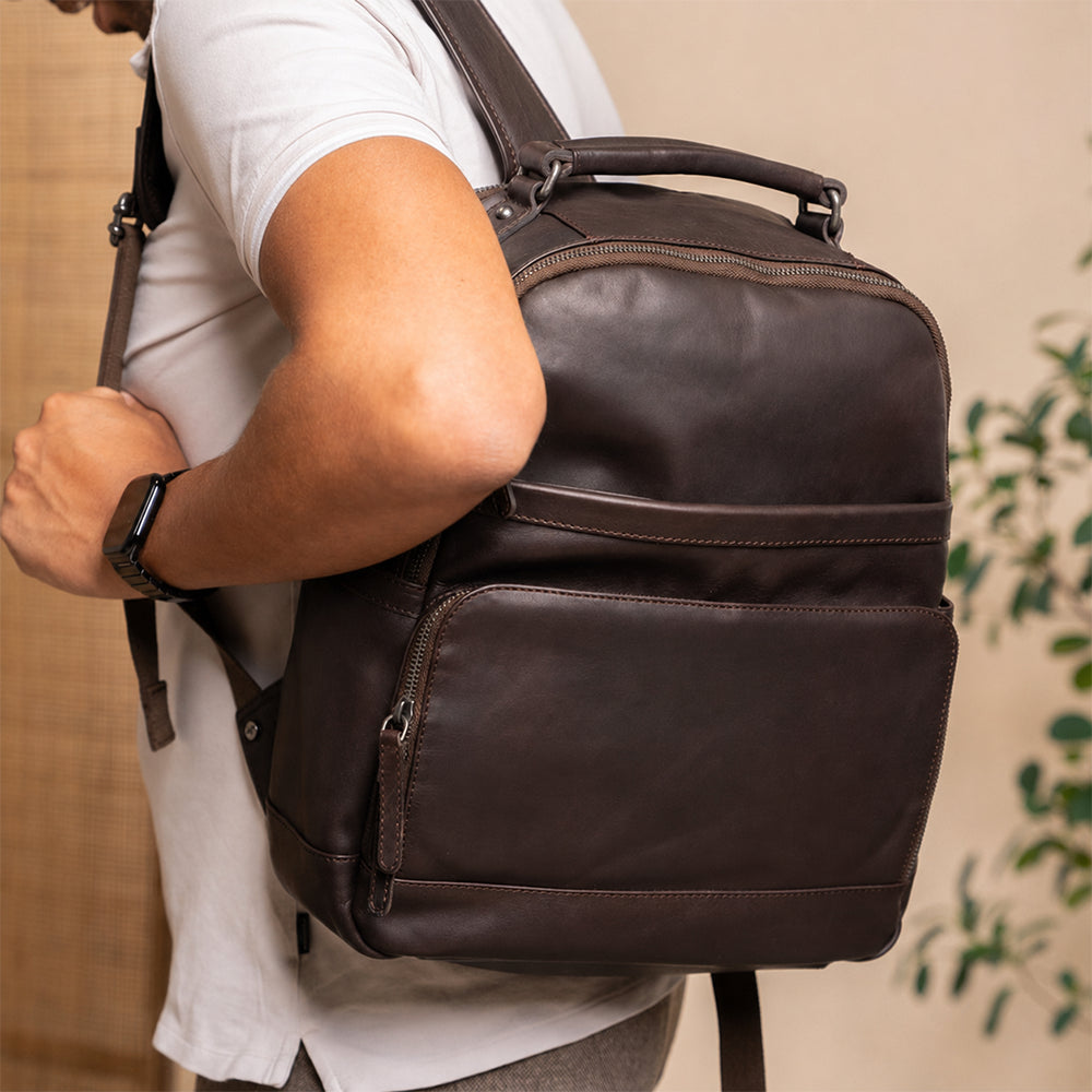 Person wearing a Vintage Handmade  brown Sheepskin leather backpack with a neutral background